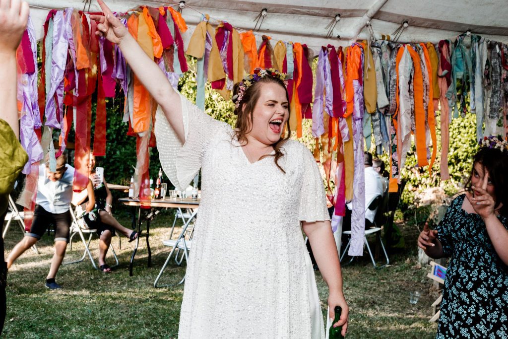 Bride dancing in her white sequin dress in her garden reception