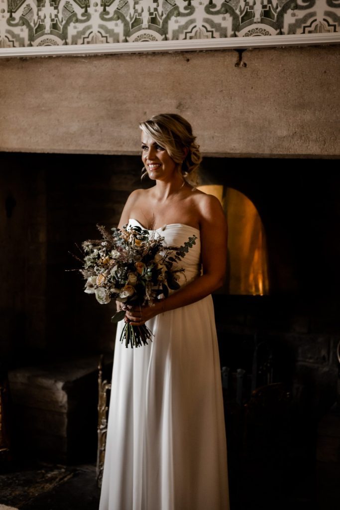 Candid photo of the Bride with her wedding flowers at their micro wedding at The Cavendish Hotel