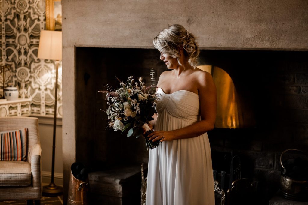 Candid photo of the Bride with her wedding flowers at their micro wedding at The Cavendish Hotel