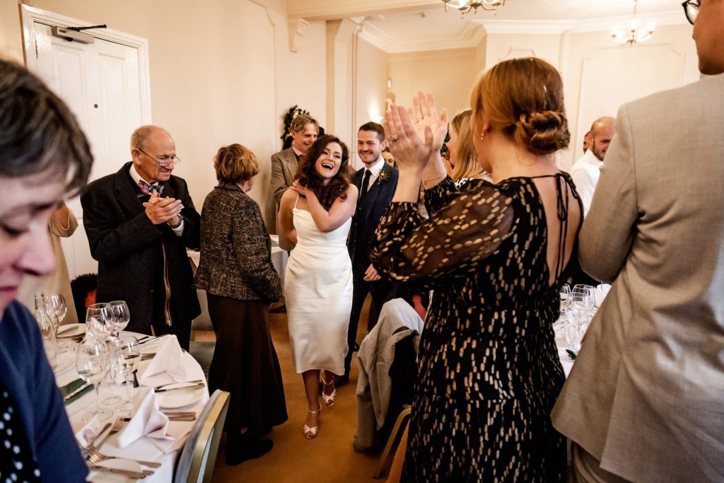 Candid photo announcing the Bride & Groom to the Wedding Breakfast at the Monsall Head Pub. Photo in colour.