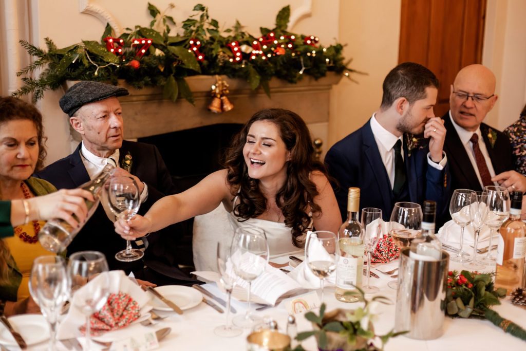 Bride toasts with prosecco at the top table at her wedding