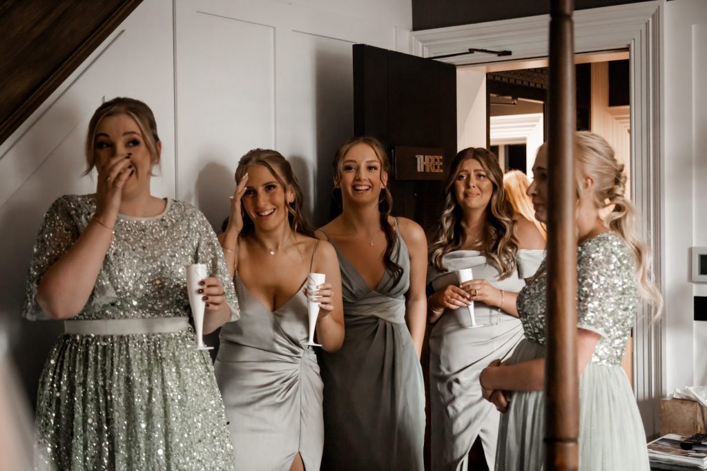 Bridesmaids reacting to seeing the bride in her wedding dress for the very first time