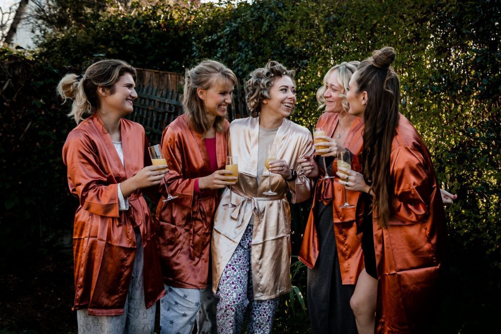 The bride and bridal party laughing together during the bridal prep with bucksfizz