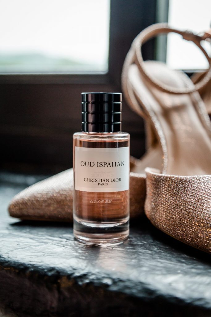 Close up of the brides wedding perfume with wedding shoes during the bridal prep