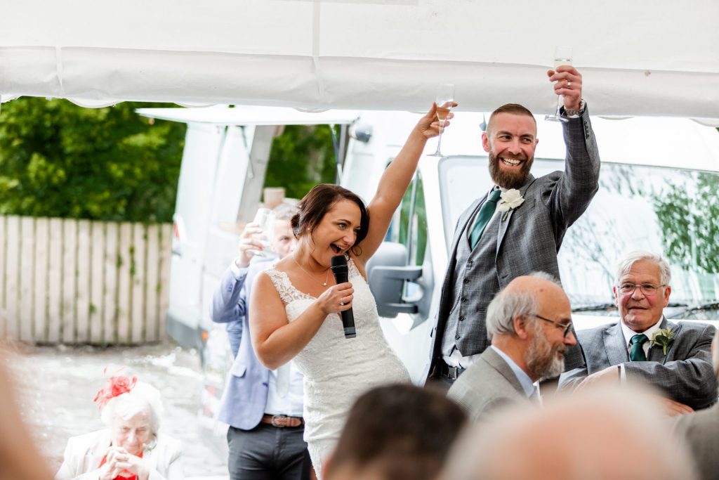 The bride and groom raising a toast during their wedding speech