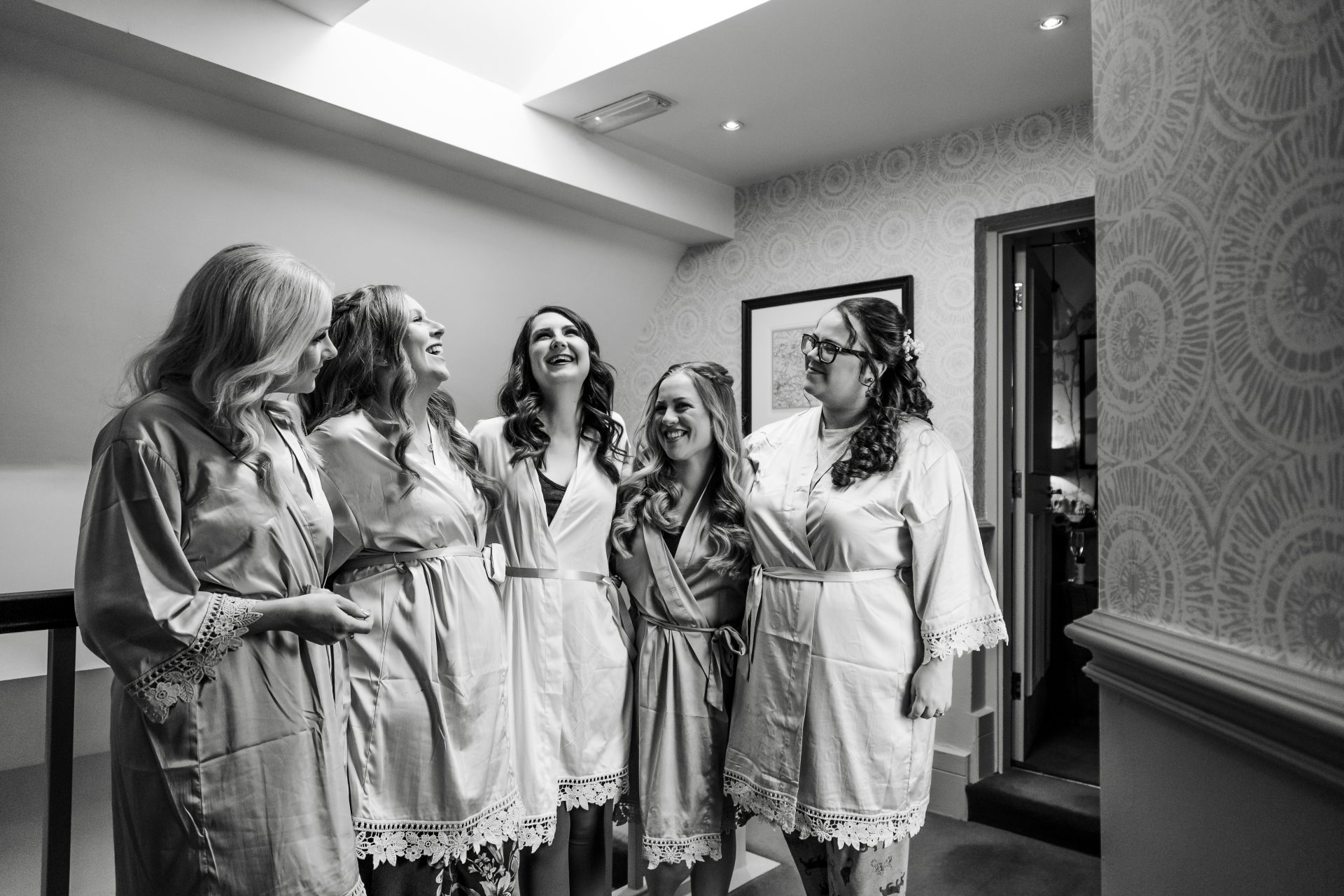 Bride and her bridesmaids stood in their robes laughing