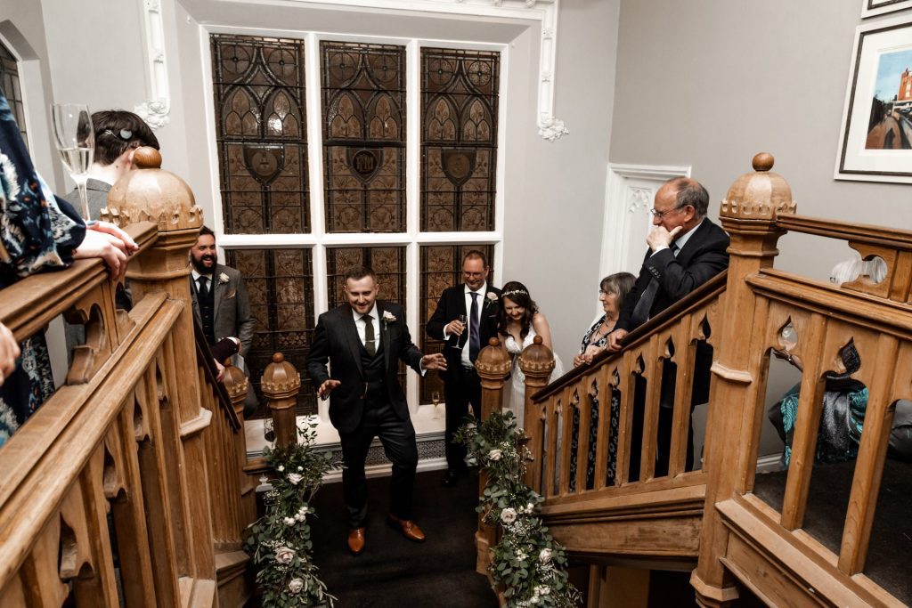 Overview shot of the groom delivering his speech on the stairs of the Didsbury House Hotel