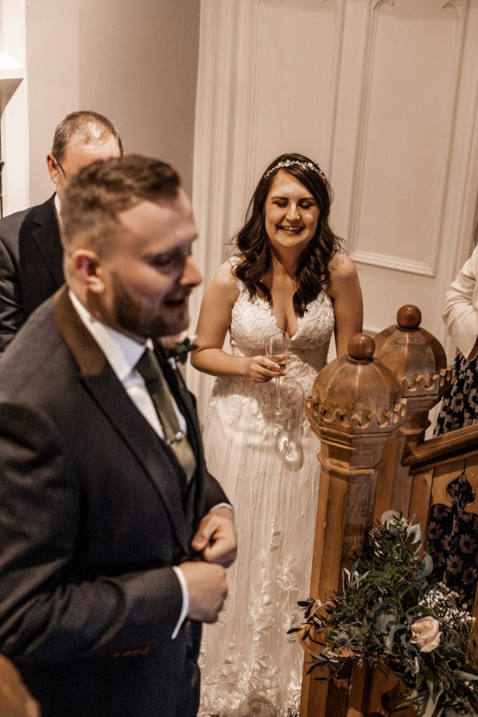 Bride laughing as her new husband delivers his speech