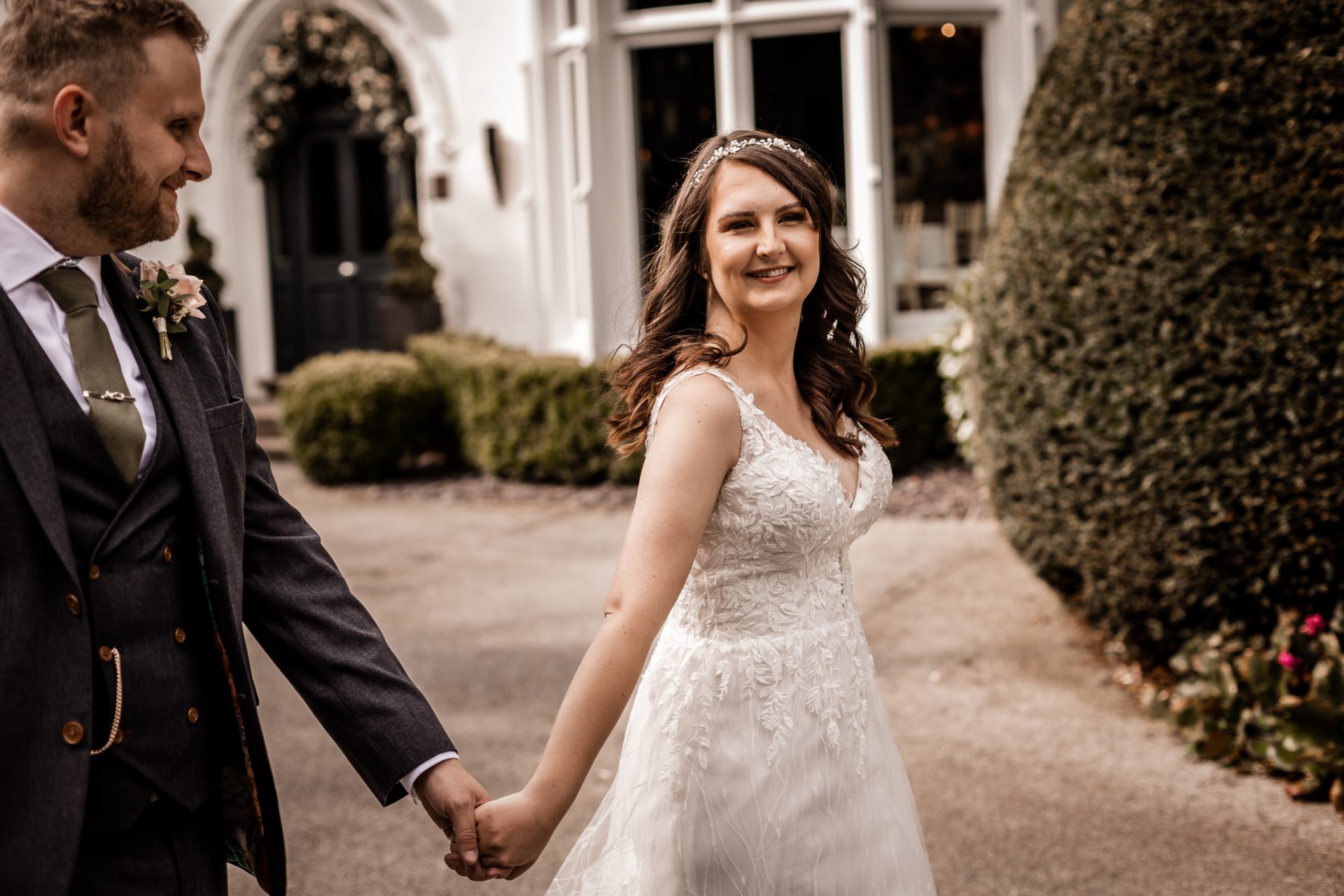 Newly married bride walks hand in hand with her new husband at The Didsbury Park Hotel, Manchester. Isabelle B Photography, Sheffield Wedding Photography