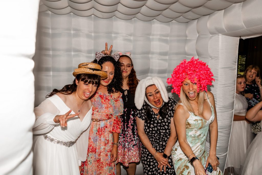 Shot of the bride and her guests in the photobooth at the Tatton Hall wedding venue