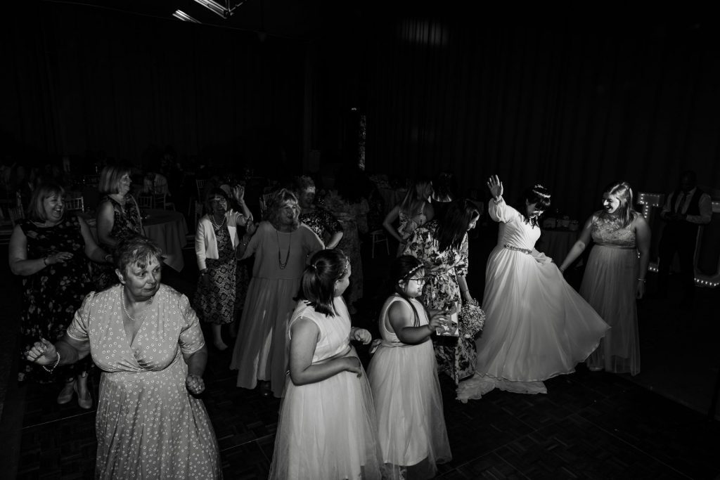 The wedding reception at Tatton Park. The dance floor is packed and the bride is highlighted in light dancing - Isabelle B Photography - Wedding Photography