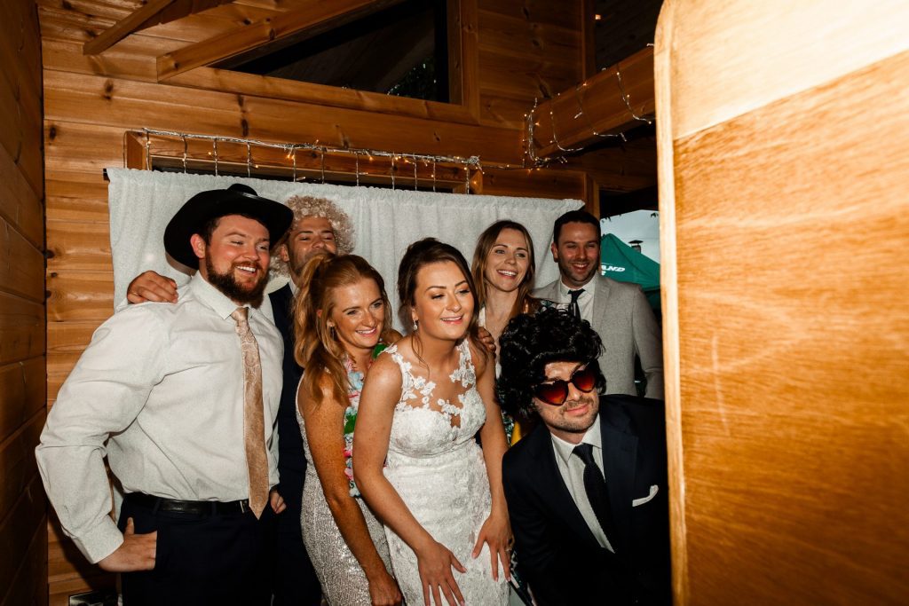 Shot of the bride and her guests in the photobooth at the Styal Lodge wedding venue