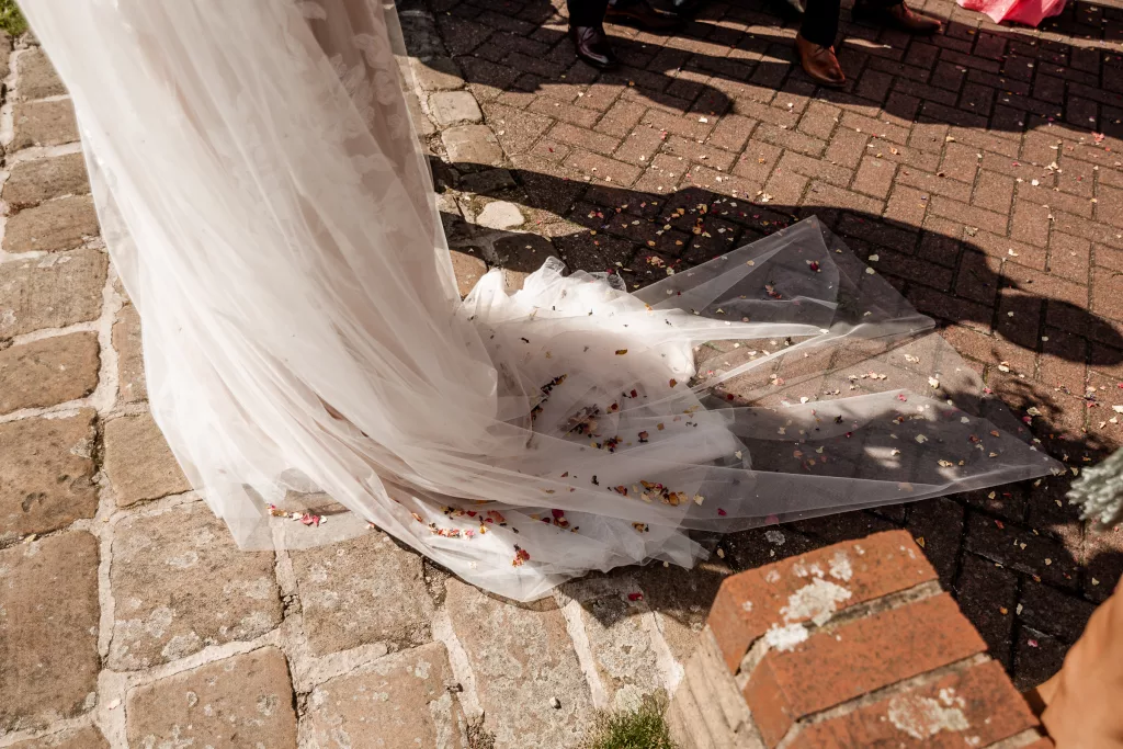 Close up shot of the brides train which is covered in confetti after the confetti moment