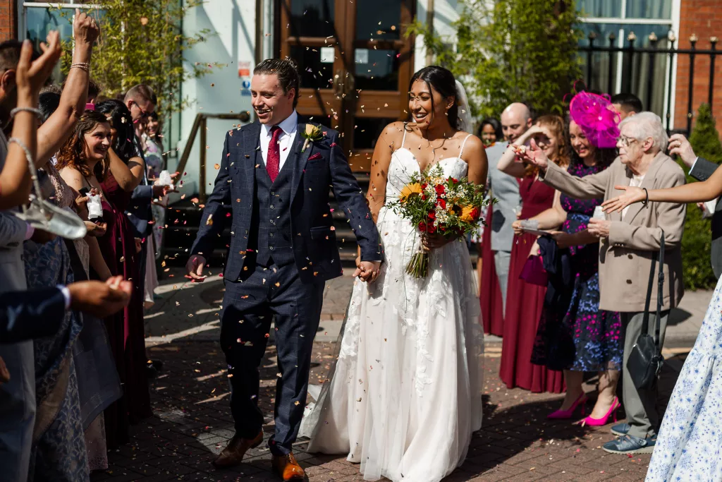 Newly married bride and groom walking through their confetti tunnel at The Crown Plaza, Sheffield