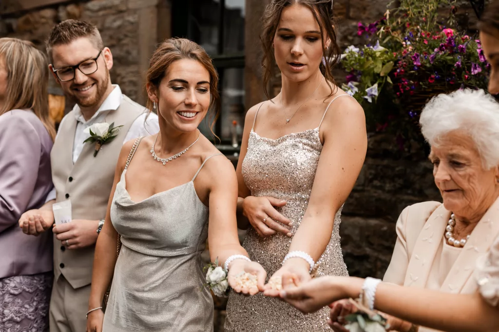 Wedding guests holding out confetti ready for the confetti shot