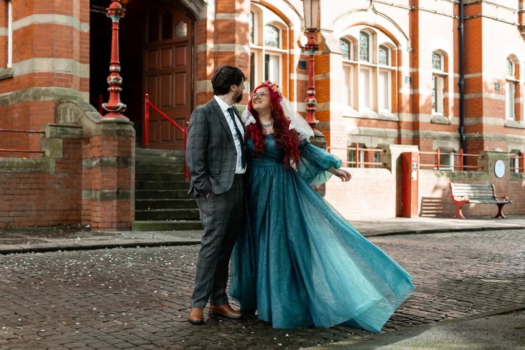 Bride and groom stood together outside Dukenfield town hall after their wedding ceremony. The bride wearing an alternative vibrant blue wedding dress