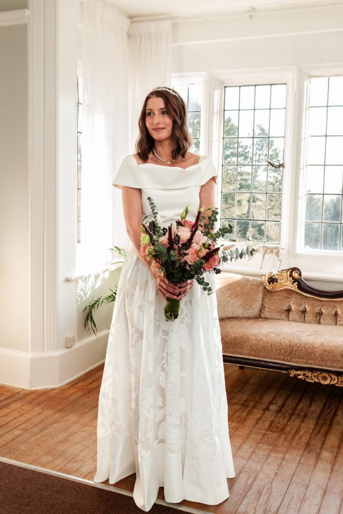 Full length of the bride holding her flower bouquet before her wedding ceremony at Whirlowbrook Hall - Isabelle B Photography